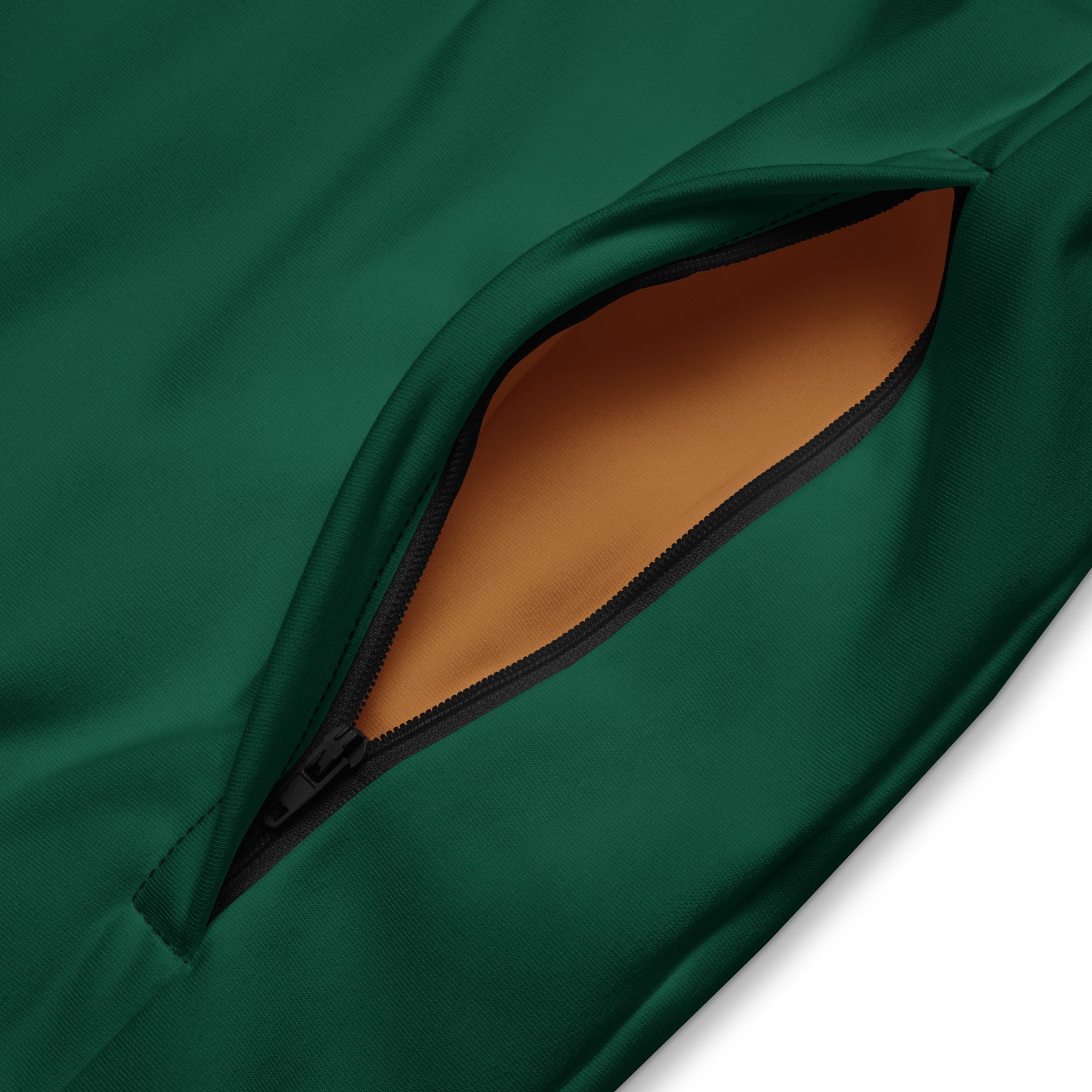 Close-up of a zippered pocket on a British racing green jacket showing smooth fabric and brown interior lining