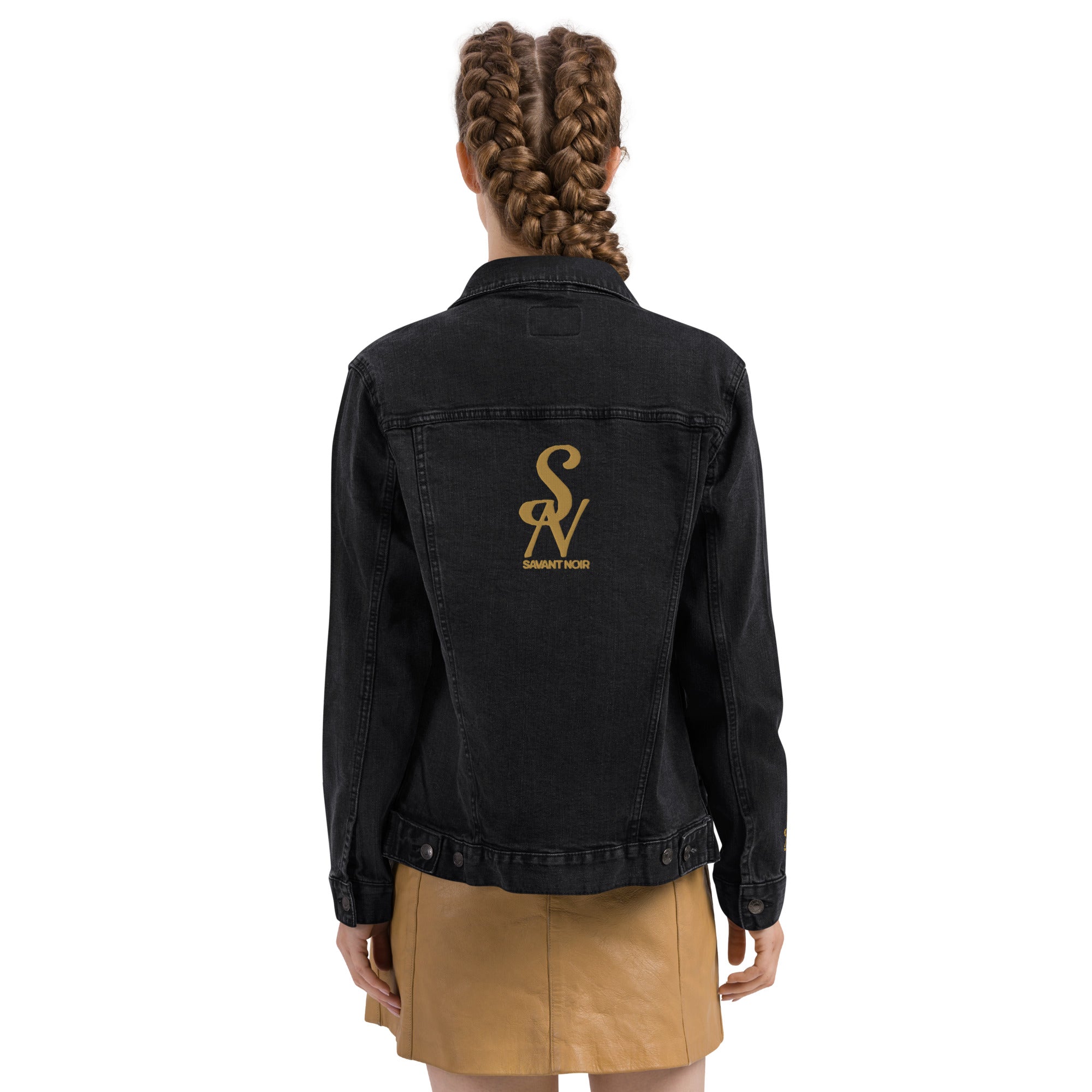 Back view of luxury black denim jacket by SAVANT NOIR with gold logo on back worn by woman