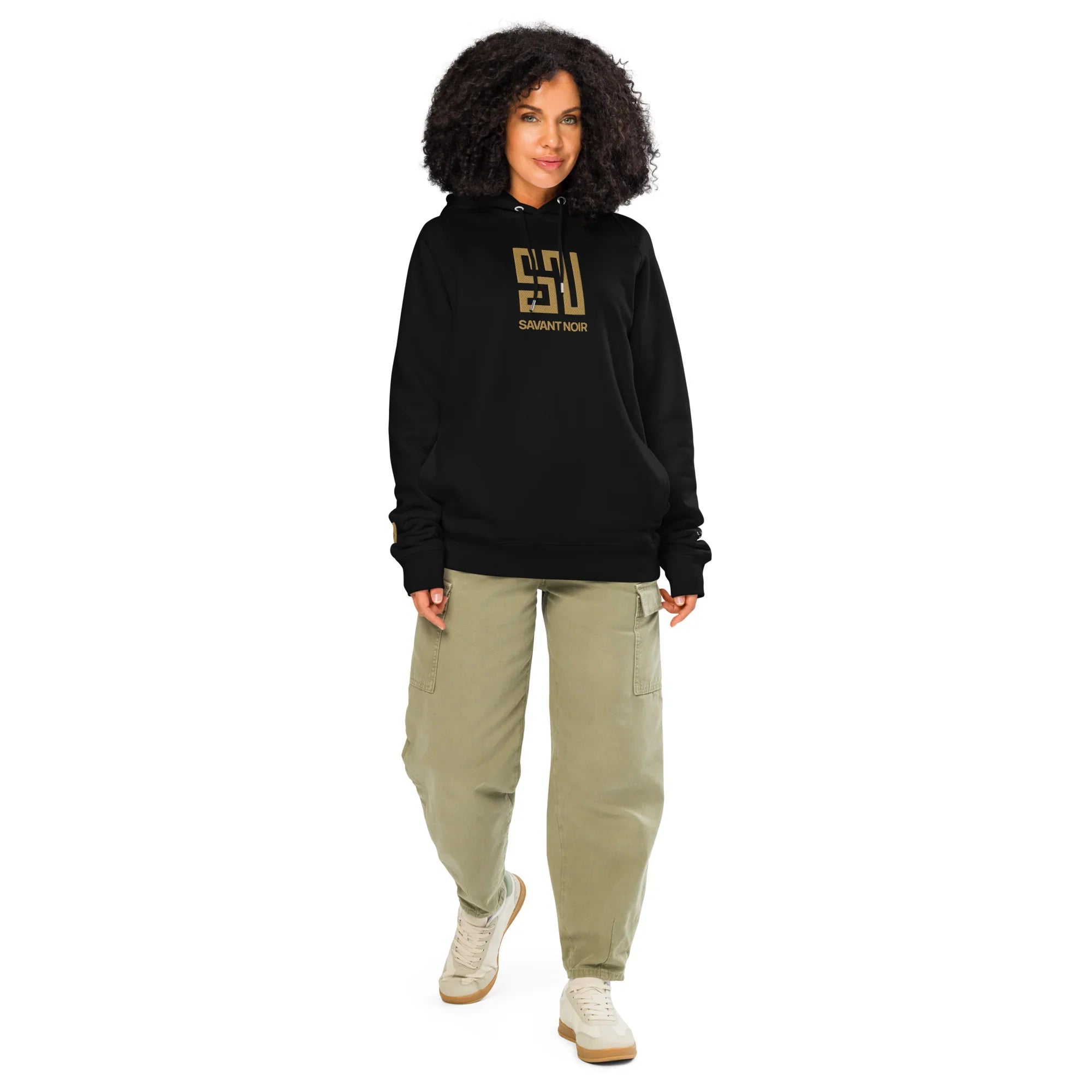 Luxury black gold embroidered hoodie by SAVANT NOIR worn by a woman with casual pants and sneakers