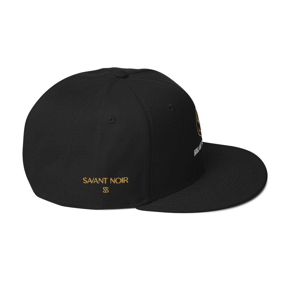 Luxury black snapback hat by SAVANT NOIR with gold embroidered logo and adjustable fit
